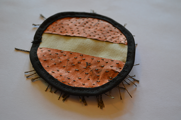 photo of back of brush button made of copper fabric and conductive threads